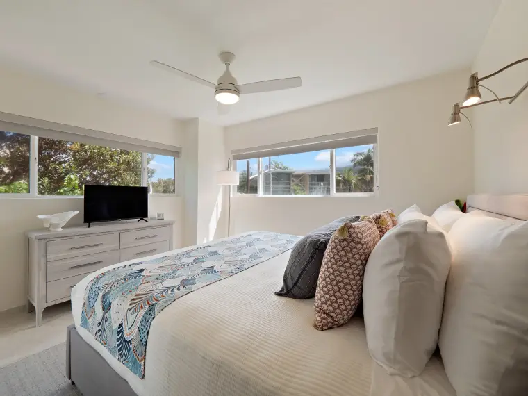 Second bedroom with TV, dresser, and window view
