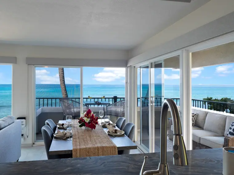 Dining table set for six with ocean and lanai beyond