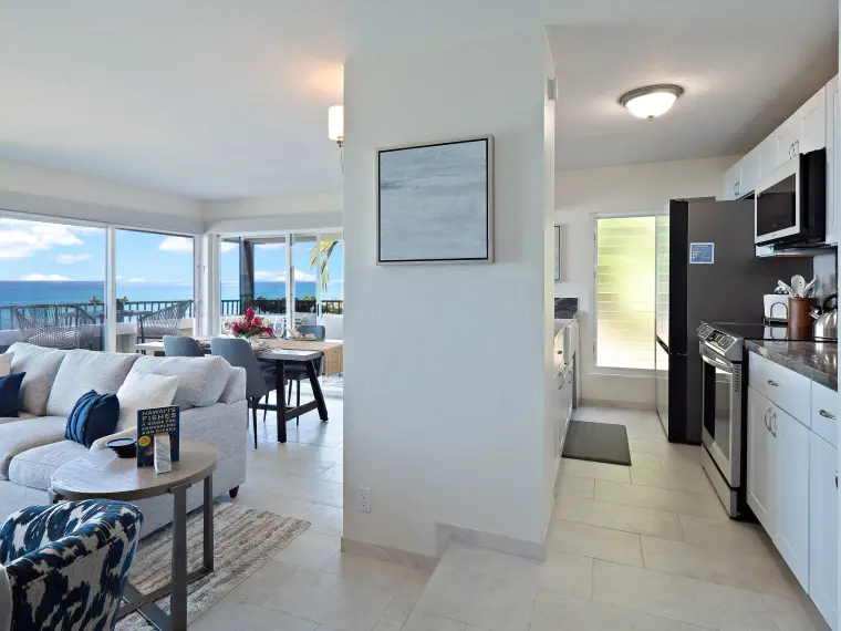 Open-plan view from living room into kitchen with ocean beyond