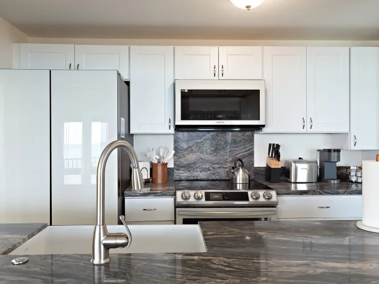 Kitchen with marble backsplash, range, and farmhouse sink